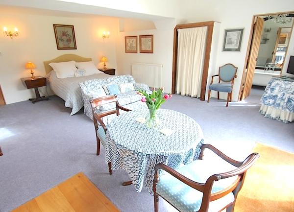 Open plan studio for couples with a double bed, dining and lounge areas.