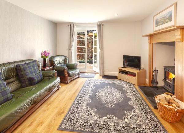 Lounge with French windows, inglenook fireplace with a wood-burner. TV and TV.