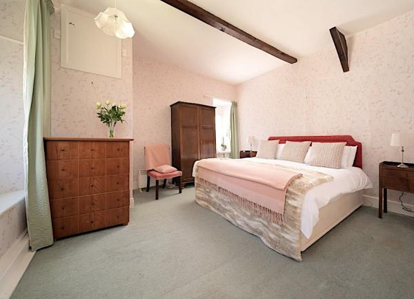 Double bedroom with a bed, wardrobe, chest of drawers and bedside lights.
