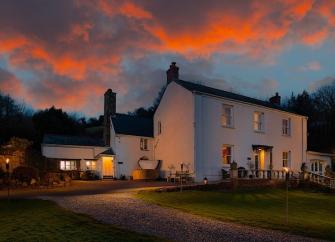 A large country house at dusk.