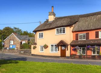 A thatched holiday cottage faces the village green in Exford.