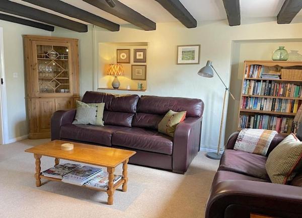 Lounge with twin leather sofas and book cases full of holiday reading books.