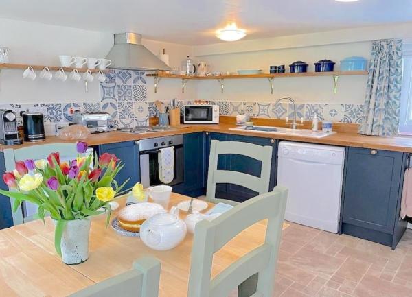 Kitchen with smart fitted units, cooker, dishwasher and microwave.