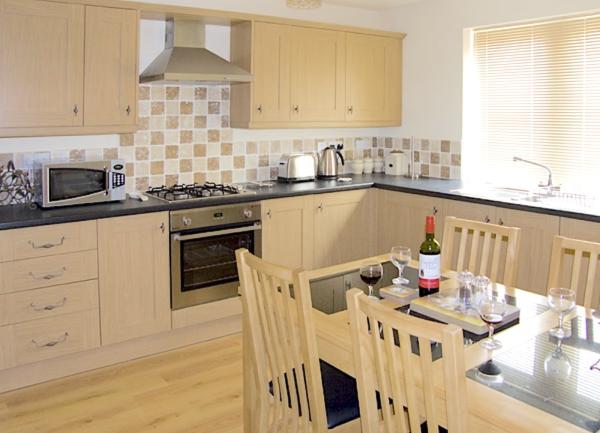 A smart, fitted kitchen-diner with oven, microwave, toaster and kettle on view.
