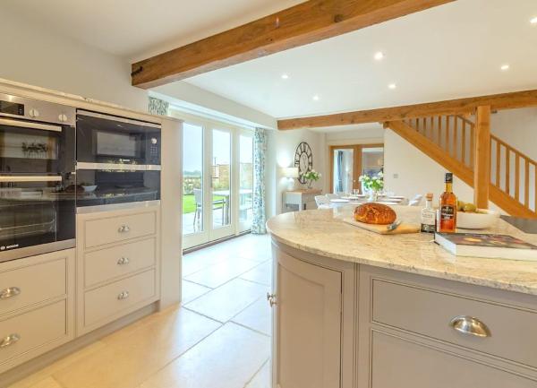 Open-plan kitchen with marble-top fitted cupboards and mid-height oven