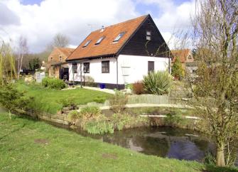 A Norfolk barn conversion overlooks a riverside lawn.