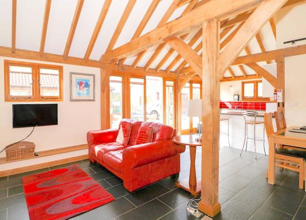 Open-plan living area with slate floor and plenty of arched pine beams and pillars.