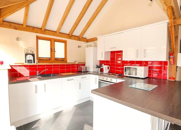 Fitted kitchen with integrated cupboards with integrated oven and dishwasher and worktop kettle, microwave and toaster.