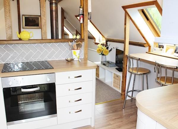 Kitchen with built-in units containing an oven and a breakfast bar.
