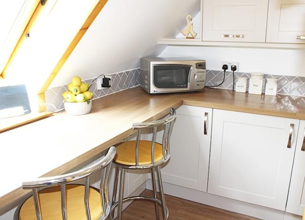 Kitchen corner with a microwave on a pine worktop.