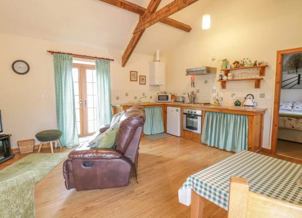 A pine-beaned fitted kitchen with fitted units and dining room table extending into a lounge area.
