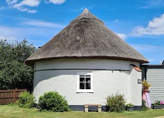 Circular exterior of cottage created within the base of a Suffolk windmill.