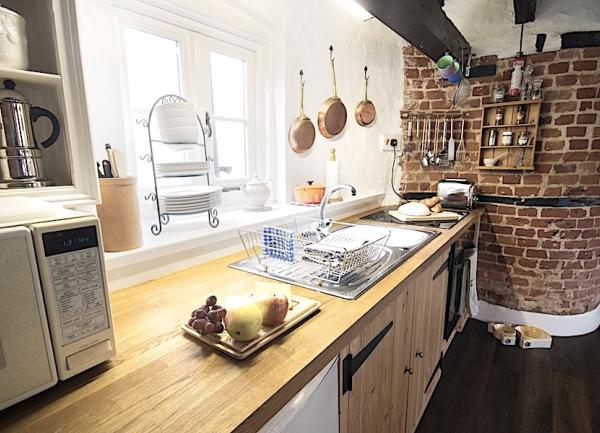kitchen with fitted cupboards pine worktops, sink and microwave. 