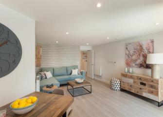 Spacious seaside apartment lounge with sofa, coffee table and sideboard.