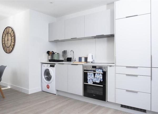Fitted kitchen with integrated oven and washing machine.