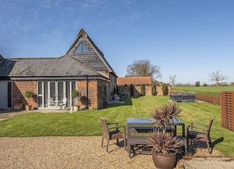 Lawns surround the exterior of a large rural holiday cottage.