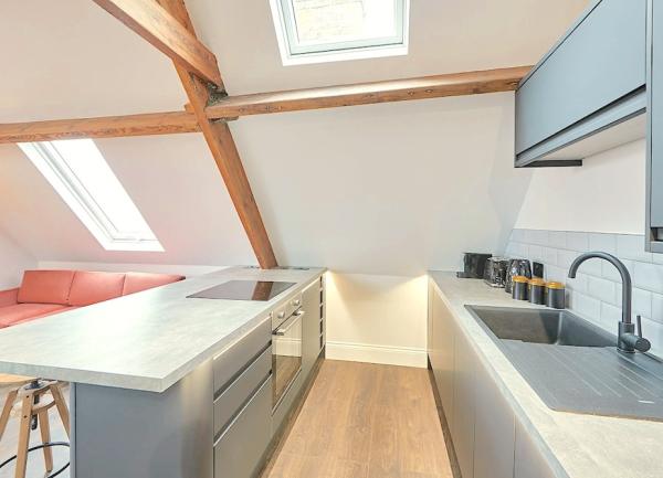 Fitted kitchen with breakfast bar, integrated oven and other white good appliances.