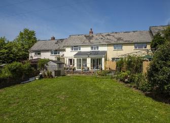 A one-bedroom, modern terraced holiday cottage with a large rear lawn.
