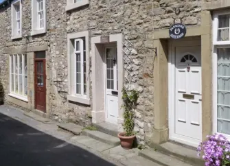 Ground floor street exterior of a stone-built terraced holiday cottage in Settle