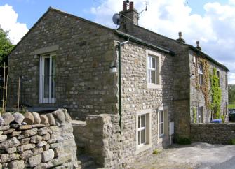 A 2-storey, end-of-terrace stone-built holiday cottage in Settle with a walled side garden.