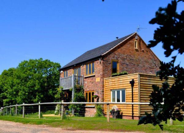 A restored barn with fenced garden and blue skies