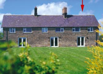 Semi-detached cottages with French windows overlook a large lawn.