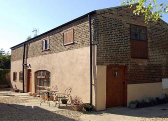 Exterior of a Cambridgeshire, brick built barn conversion ina courtyard.