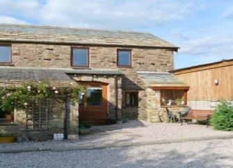 An extended 2-storey Scottish barn conversion with one wall lined by roses