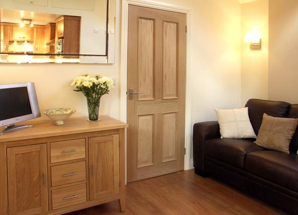 A cottage lounge corner with a sofa, sideboard and TV.