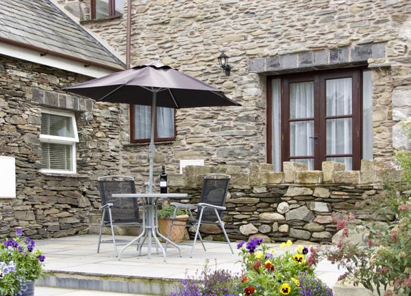 Paved patio with outdoor table and chairs.