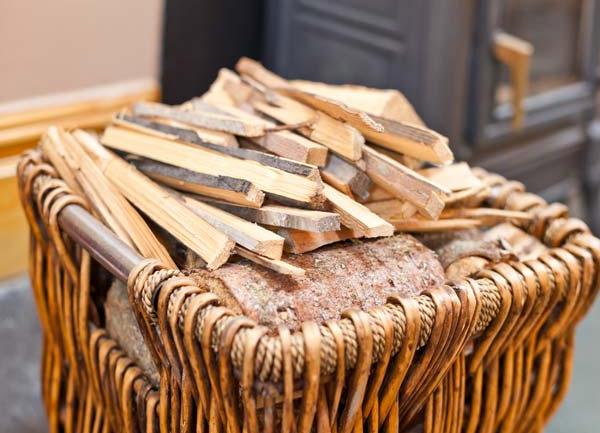 A wicker basket with logs and kindling.