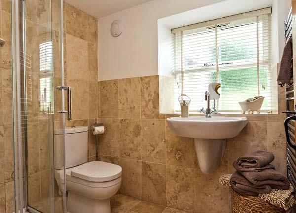 Tiled shower room with basin and WC.