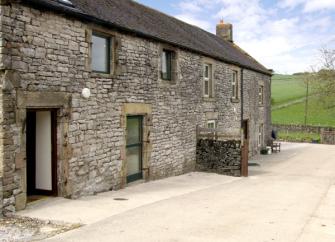 A stone-built country cottage overlooks a large courtyard