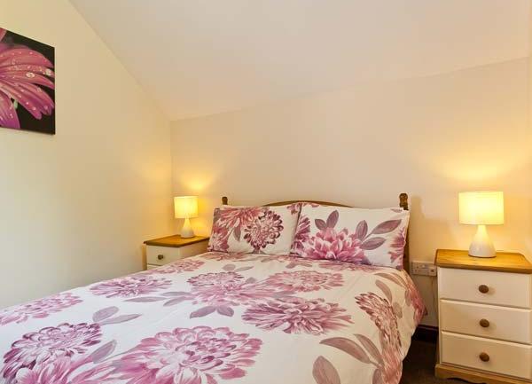 Double bed with bedside tables and table lights.