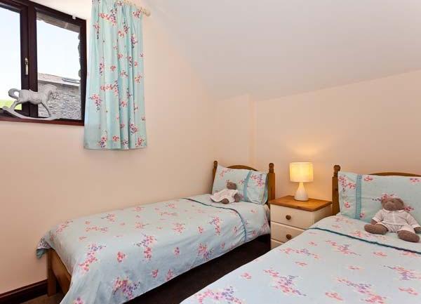 Bedroom with twin beds and bedside cabinet with table lamp.