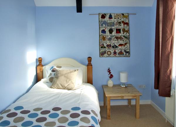 A single bedroom with a bedside table and table lamp