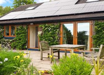 A contemporary Staffordshire Holiday cottage with floor-to-ceiling French windows overlooks a terrace and flower garden.