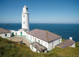 A Lighthouse complex on a clifftop with panoramic ocean views.