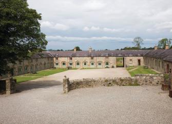 Two rows of cottages converted from stables line two-sides of a courtyard.