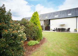 A large single storey barn with a private, secure, hedge-lined lawn.