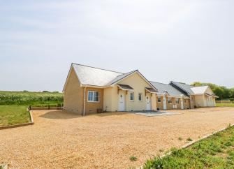 A ground-floor countryside cottage with a central gable extension overlooks a large courtyard.