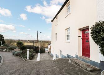 A 3-storey-rendered Herefordshire farmhouse overlooks a block-paved courtyard