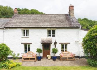 Double-fronted mill cottage with flagstone patio and lawn.