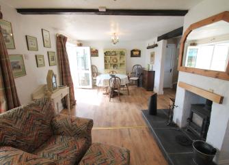 An open plan lounge and dining area with a woodburner in an Exmoor cottage