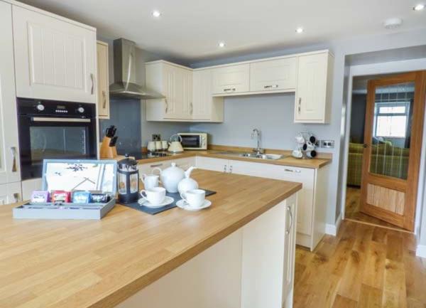 A smart fitted kitchen with pine worktops, built-in mid-height oven and a dishwasher.