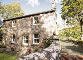 A stone-built holiday cottage in Stanton Bridge overlooks a tree-lined country lane
