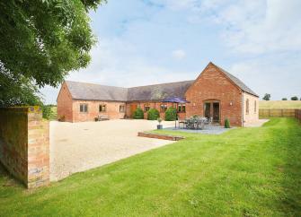 A large C-shaped single-storey rural cottage built around a courtyard.