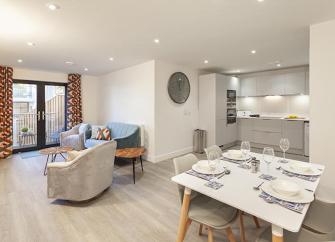 Open-plan living areas in a holiday apartment with French doors to a balcony.