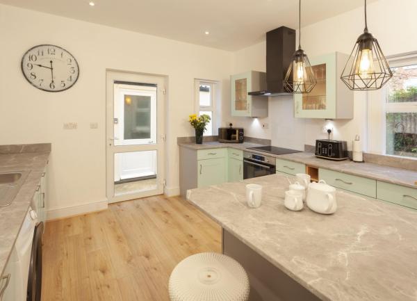A U-shaped kitchen with fitted units having a marble-topped Island block in the centre. 