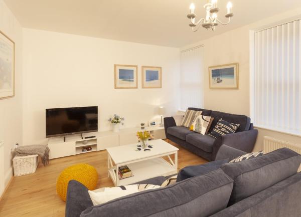 Lounge with twin 2-seat sofas, coffee table and a wall-mounted wiide-screen TV.